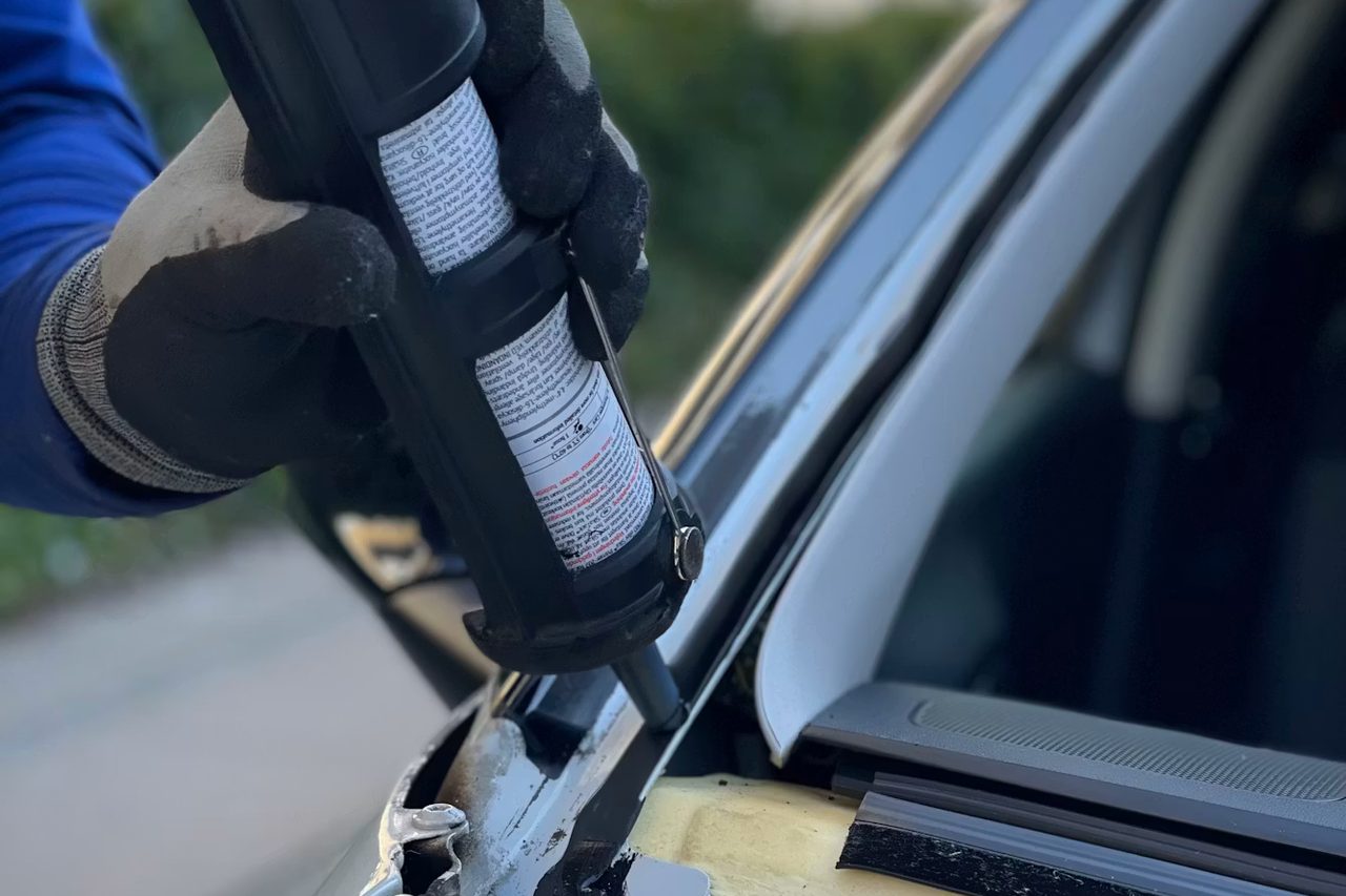 Close-up of a resin injection tool repairing a rock chip in a windshield