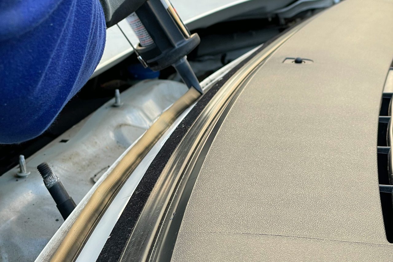 Technician setting a new windshield into a vehicle in Reno